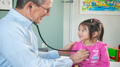 طبيب يفحص طفلة.. صورة تعبيرية عن أسباب متلازمة توريت 