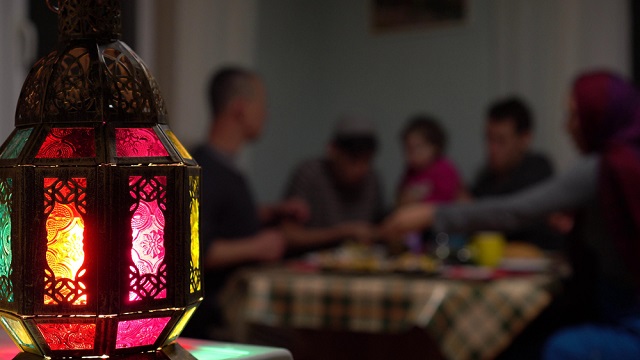 فانوس رمضان ويبدو في الخلفية عائلة تفطر في رمضان 