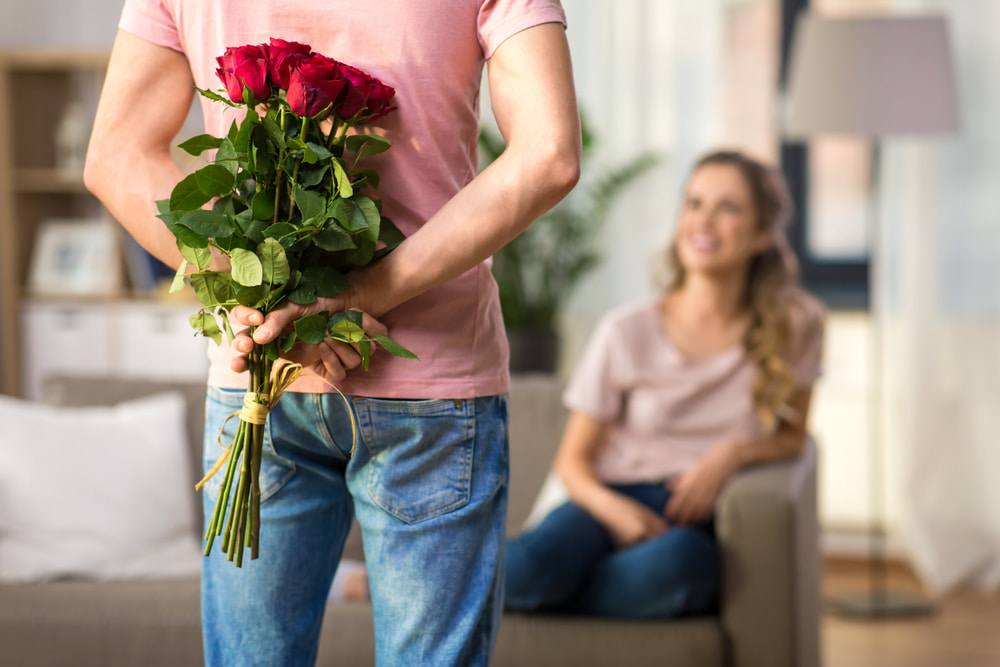 رجل يقدم لزوجته الورود.. تعبيرية عن أفكار هدايا عيد الزواج الاول