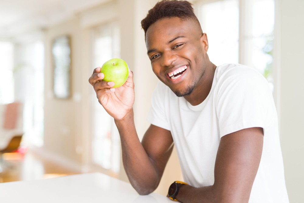رجل يتناول التفاح الأخضر.. تعبيرية عن فوائد التفاح الأخضر للصحة 