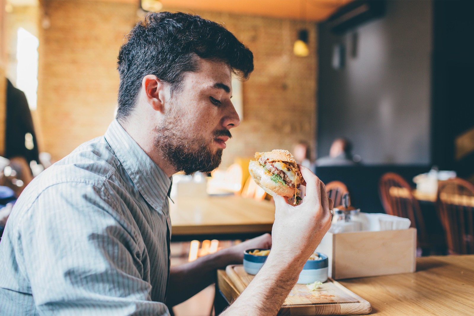 رجل يتناول طعامًا تعبيرية عن الوجبات السريعة - مصدر الصورة: Shutterstock