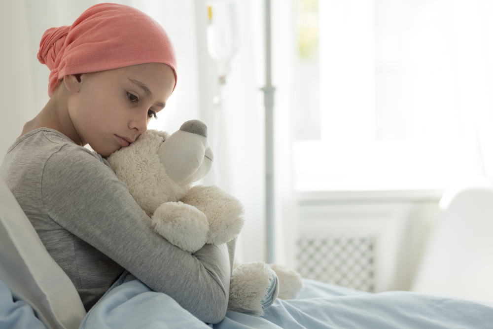 طفلة تحتضن وسادتها بسبب الإصابة بسرطان الدم 