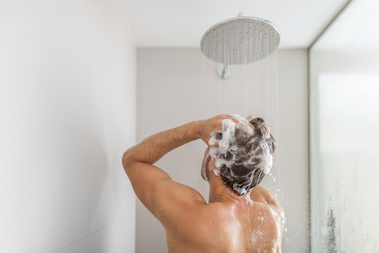 رجل يغسل شعره لتصفيفٍ مثاليّ في 3 خطوات سهلة